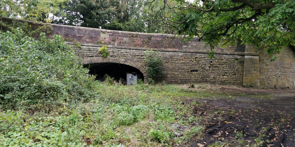 The West side of the bridge that once carried the A367 and now carries the layby. This approximately half hal way along the Somersetshire Coal Canal.